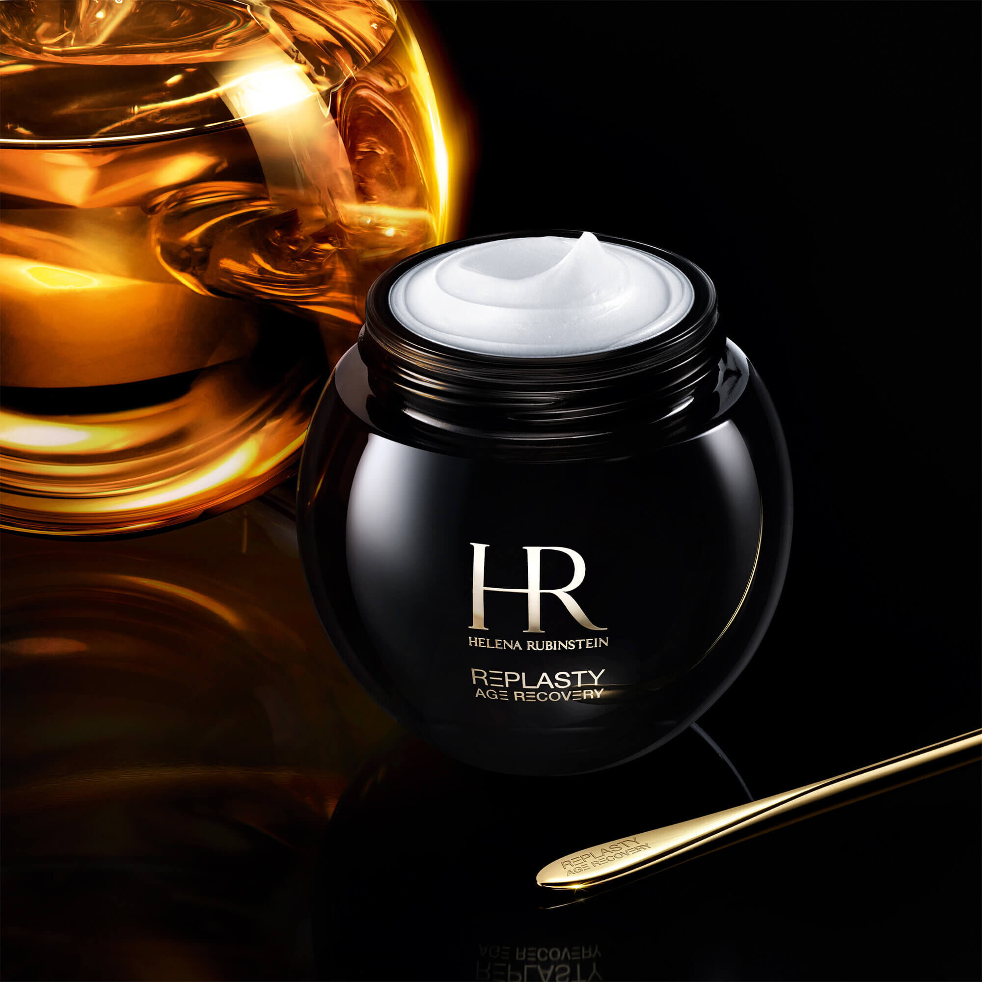 Offener Tiegel der Creme Helena Rubinstein Replasty Age Recovery Night 30PX mit einem goldenen Molekul auf schwarzem Hintergrund