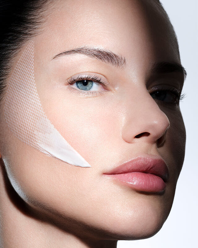 Frauengesicht mit Helena Rubinstein REPLASTY Creme und innovativer Bandage-Textur auf der Wange.