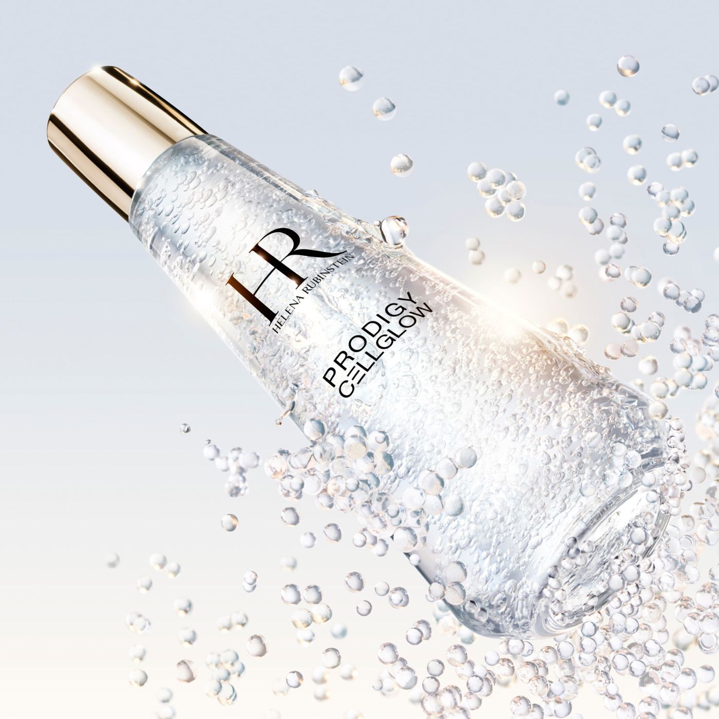 „Helena Rubinstein Prodigy Cellglow“ Serumflasche, gefullt mit Blaschen, geneigt und umgeben von funkelnden schwebenden Blaschen, auf hellem und leuchtendem Hintergrund.